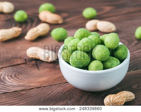 Peanut Snack For Beer, Wine, Party Bar. Salted Peanuts In Green Vasabi Glaze On Brown Wooden Table. 