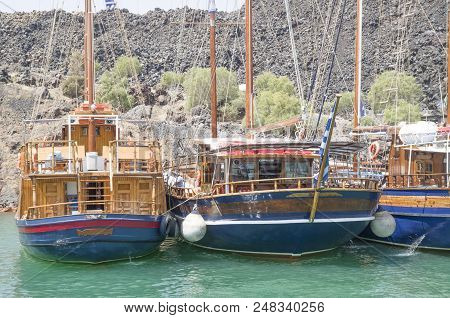 Many Wooden Ships On Port Of Nea Kameni Volcanic Island Near Santorini