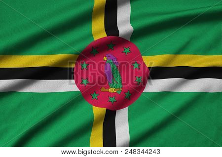 Dominica Flag  Is Depicted On A Sports Cloth Fabric With Many Folds. Sport Team Waving Banner