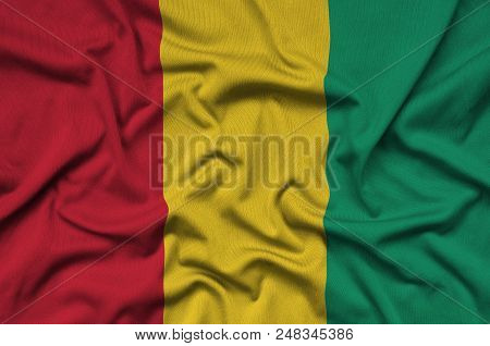 Guinea Flag  Is Depicted On A Sports Cloth Fabric With Many Folds. Sport Team Waving Banner