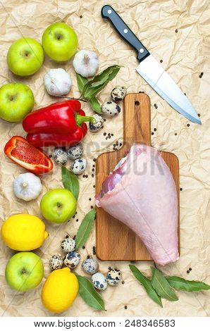Raw Turkey Thigh Garlic Apples Lemon Red Bell Pepper Quail Eggs Spices On A Wooden Board. Top View O