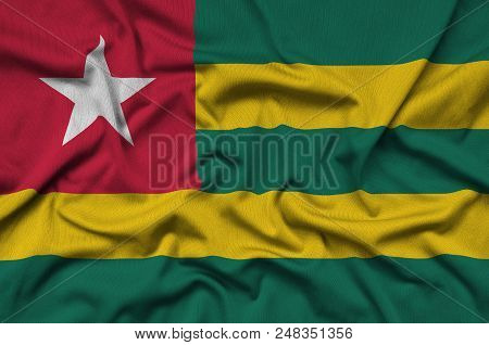 Togo Flag  Is Depicted On A Sports Cloth Fabric With Many Folds. Sport Team Waving Banner