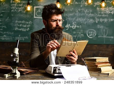 Pretty Teacher Helping Pupil In Classroom At The Elementary School, Tutor Asks The Tutee To Find The