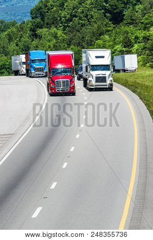 Several 18-wheelers Proceed Down The Highway.  The Image Is Composed Loosely To Provide Abundant Cop