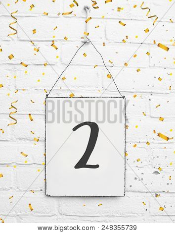 2 Two Years Old Birthday Party Card Text With Golden Confetti Metal Plate White Brick Background