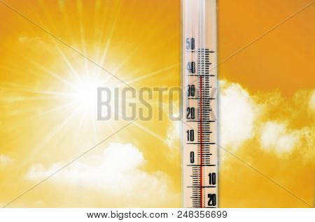 Thermometer Against The Background Of An Orange Yellow Hot Glow Of Clouds And Sun, Concept Of Hot We