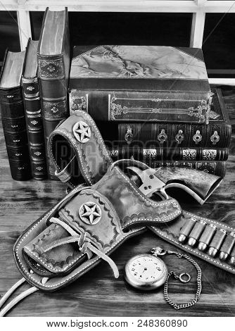 Old Cowboy Gun In Holster With Pocket Watch And Literature In Black And White.