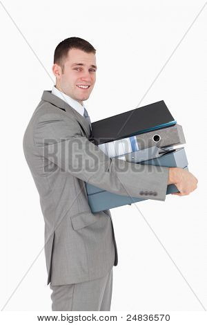 Retrato de um jovem empresário segurando uma pilha de ligantes contra um fundo branco