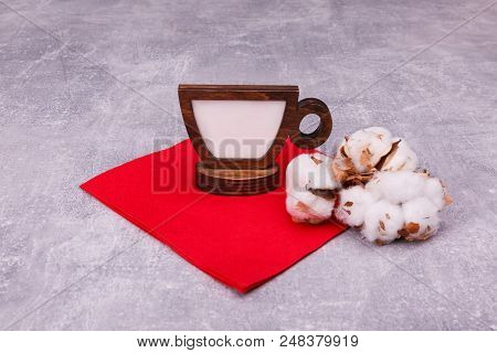 A Wooden False Cup With White Centre Is Situated On A Red Napkin, Decorated With Pussy-willow.