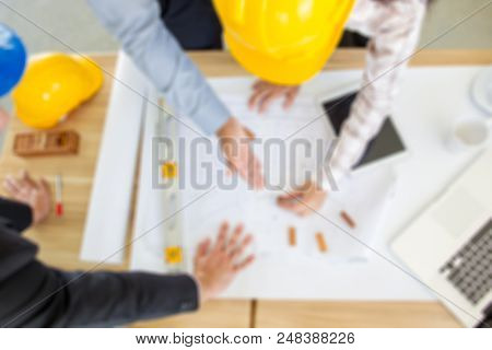 Blurred Phtograph Of A Group Of People Planing A Project Background.