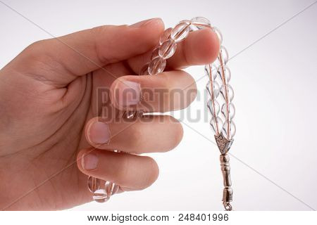 Hand Holding A Tespih On A White Background