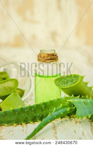 Aloe Vera Extract In A Small Bottle And Pieces On The Table. Selective Focus.