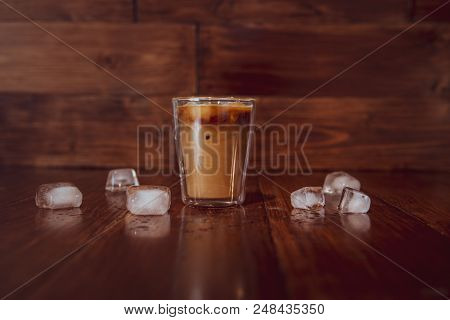 Coffee With Milk And Ice On Wooden Background. With Ice Cubes On Table.
