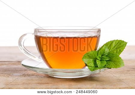 Glass Cup Of Tea With Mint Leaves On Wooden Table