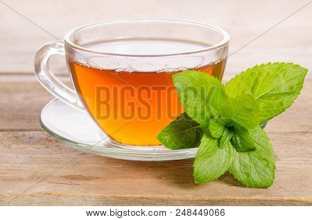 Glass Cup Of Tea With Mint Leaves On Wooden Table