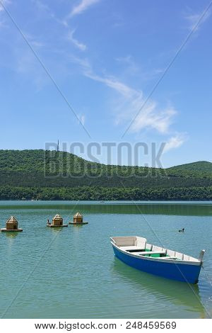 Bright Blue Empty Rowing Boat For Riding On The Green Water Of The Mountain Lake Abrau-durso