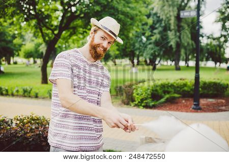 Photo Theme Small Business Cooking Sweets. A Young Man With A Beard Of A Caucasian Trader In The Hat
