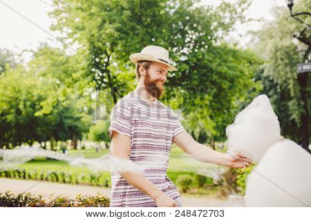 Photo Theme Small Business Cooking Sweets. A Young Man With A Beard Of A Caucasian Trader In The Hat