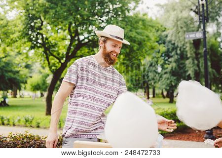 Photo Theme Small Business Cooking Sweets. A Young Man With A Beard Of A Caucasian Trader In The Hat