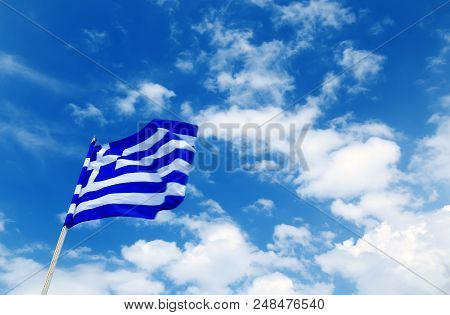The Greek Flag On A Blue Partly Cloudy Sky,