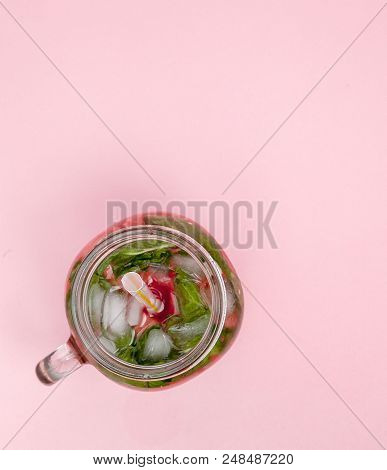 Jar Of Cold Fresh Lemonade With Piece Of Watermelon And Ice On Pink Background.