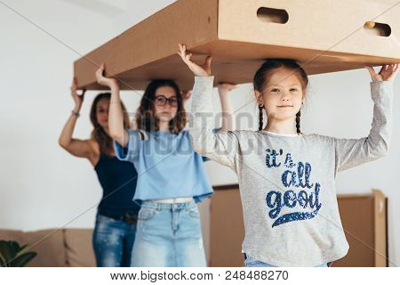 Family With Cardboard Boxes. Moving Into New Home.