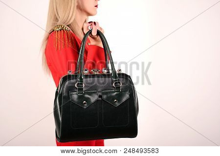 Slender Girl In A Red Jacket And Jeans With A Green Bag Stands Sideways