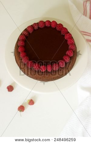 Chocolate Brownie Cake With Raspberries And Chocolate Icing On A Light Background. Selective Focus.