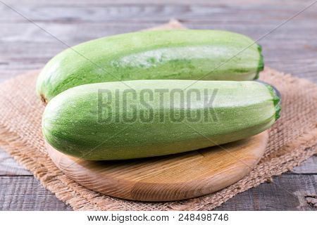Courgettes Zucchini On Cutting Board On Wooden Table