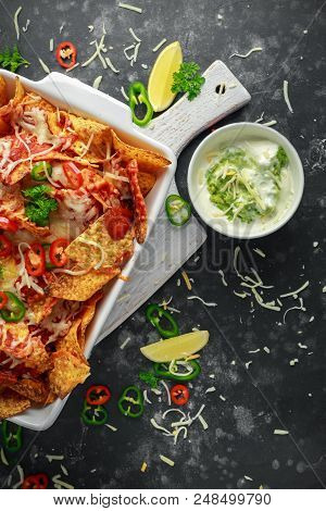 Maxican-style Tortilla Nachos Chips Topped With Tomato Salsa, Sliced Chilies And Melted Cheese Serve