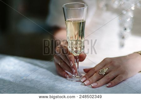 Woman Holding A Glass Of Champagne. Bride. Wedding Dress. Close Up Picture