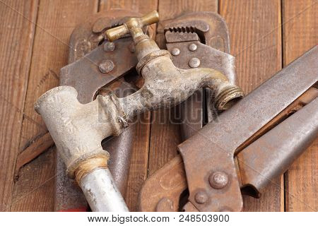 Plumber Tool Faucet For House Repair Lying On Wooden Background
