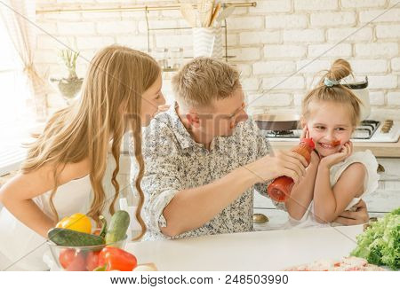 dad with two little daughters have a fun in the kitchen