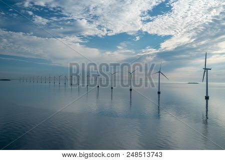Offshore Windmill Park Alternative Energy. Windmills In The Sea With Reflection In The Morning, Denm