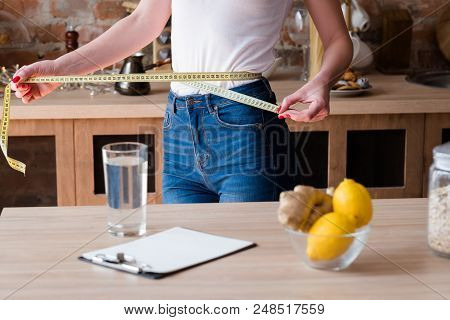 Lemon And Ginger Detox Diet For Weight Loss. Slim And Fit Body. Woman Measuring Her Waist With A Tap