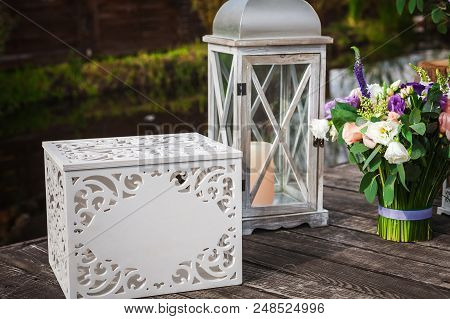 Bunch Of Fresh Beautiful Flowers, White Box And Candle In Classic Vintage Openwork Candelabrum Stand