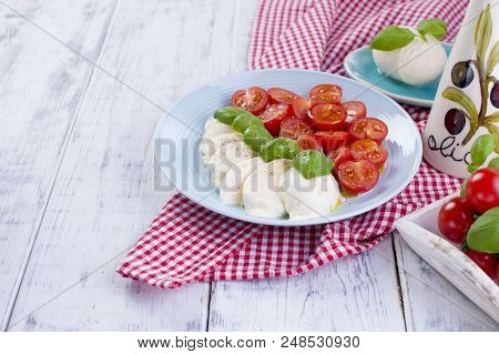 Traditional Italian Salad With Fresh Cherry Tomatoes And Soft Mazarella Cheese, With Basil And Olive