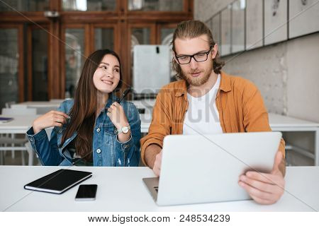 Portrait Of Young Students Sitting In Auditorium And Working Together With Laptop And Mobile Phone O