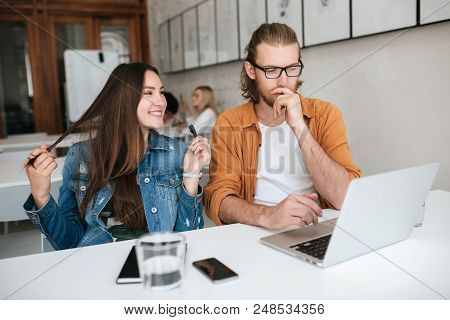 Portrait Of Young Students Sitting In Auditorium And Working Together With Laptop And Mobile Phone O