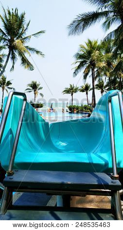Blue Slider In The Swimming Pool In Front Of The Beach.