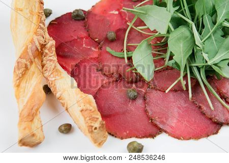 Delicious Dried Beef Basturma With Cheese, Mozzarella, Potatoes And Spinach Leaves On A Plate On Bla