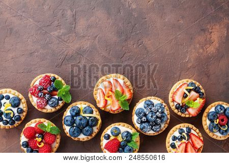 Delicious Berry Tartlets Or Cake With Cream Cheese Decorated Lemon Peel And Mint Leaf From Above. Ta