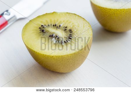 Close-up Of A Halved Kiwi Fruit On A White Background. 
View To A Sliced Kiwi On A White Table.