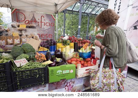 Briancon, France, 10 June 2018: Woman Checks Vegetables On Open Air Market Of Briancon In The French