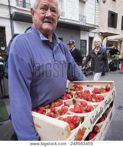 Briancon, France, 10 June 2018: Man Carries Case Full Of Strawberries On Open Air Market In French T