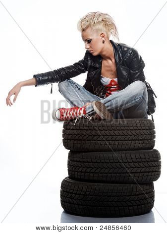 Punk girl sitting on tires.