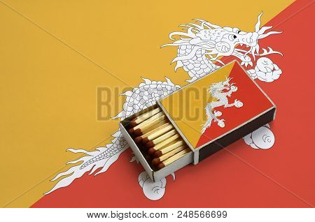 Bhutan Flag  Is Shown In An Open Matchbox, Which Is Filled With Matches And Lies On A Large Flag.