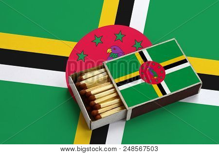 Dominica Flag  Is Shown In An Open Matchbox, Which Is Filled With Matches And Lies On A Large Flag.