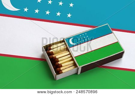 Uzbekistan Flag  Is Shown In An Open Matchbox, Which Is Filled With Matches And Lies On A Large Flag