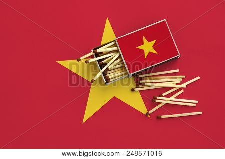 Vietnam Flag  Is Shown On An Open Matchbox, From Which Several Matches Fall And Lies On A Large Flag